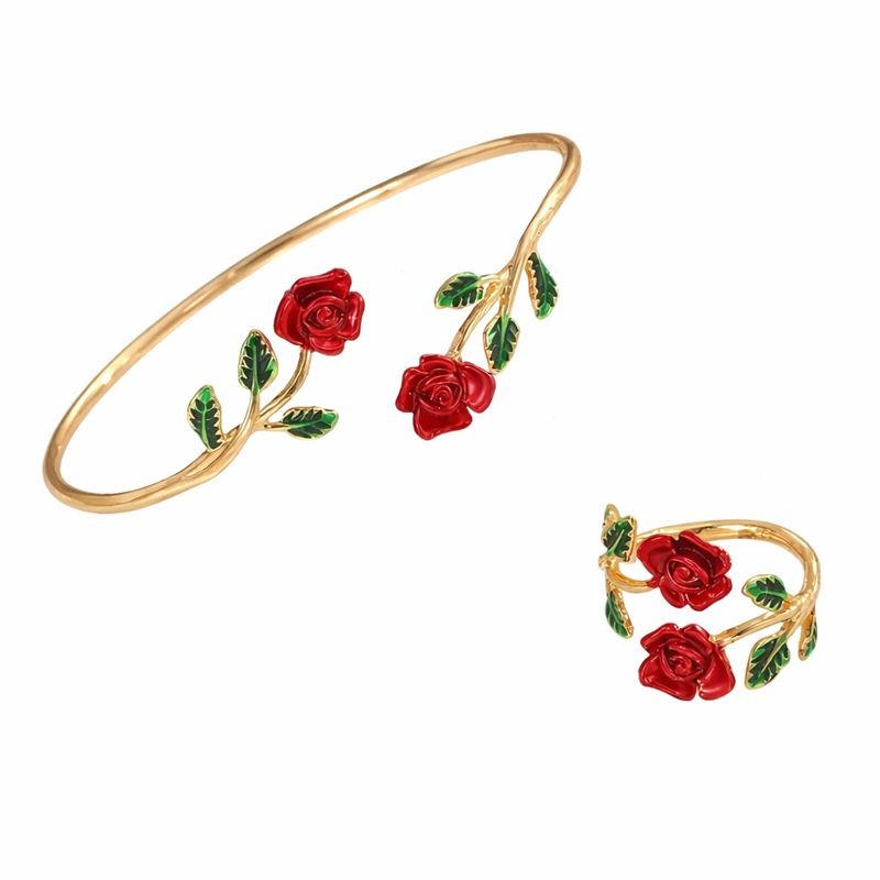 Conjunto de pulseira e anel dourados com rosas vermelhas esmaltadas e folhas verdes sobre fundo claro